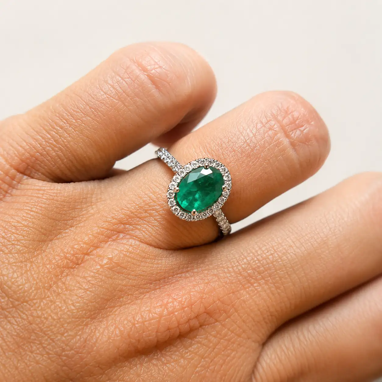 Anillo con esmeralda oval y brazo y orla de diamantes corsia