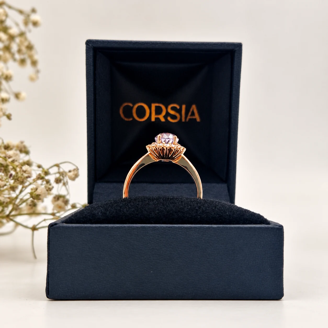 Anillo de oro rosa con zafiro natural rosa y orla de diamantes corsia